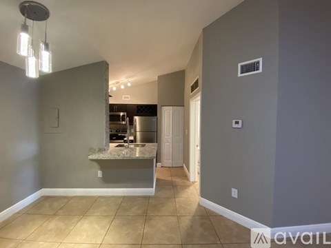 A kitchen area with a counter and a refrigerator.