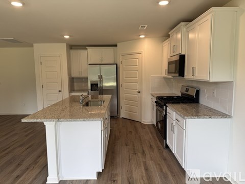 A kitchen with white cabinets and a granite countertop.