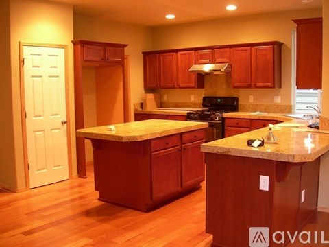 A kitchen with wooden cabinets and a marble countertop.