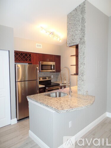 A kitchen with a granite countertop and stainless steel appliances.