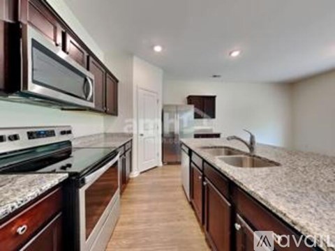 A kitchen with dark wood cabinets and granite countertops.