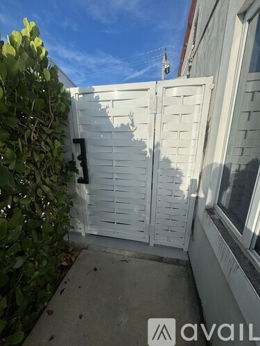 A white gate is closed and locked.