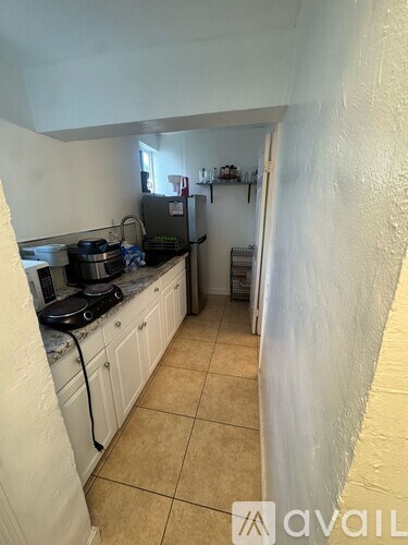 A kitchen with white cabinets and a black stove top.