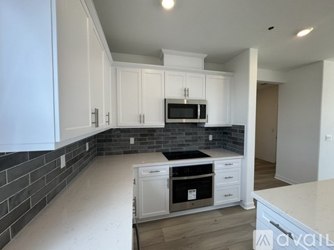 A kitchen with white cabinets and a black countertop.