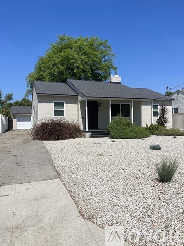 A house with a gravel driveway in front.