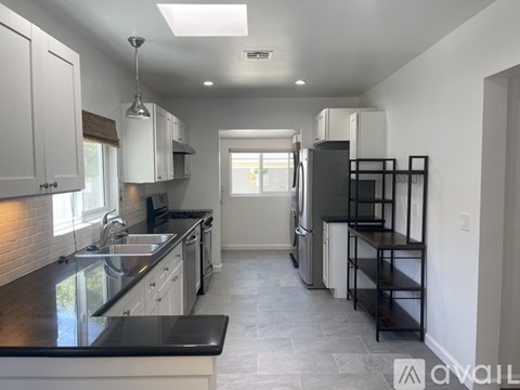 A kitchen with black countertops and white cabinets.