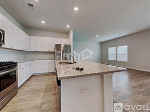 A kitchen with white cabinets and a granite countertop.