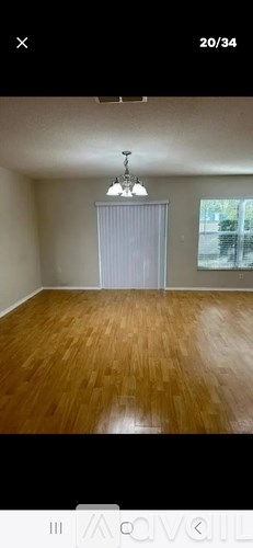 A room with wooden flooring and a chandelier.