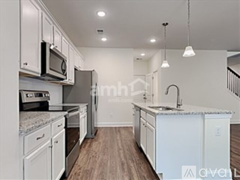 A kitchen with white cabinets and appliances.