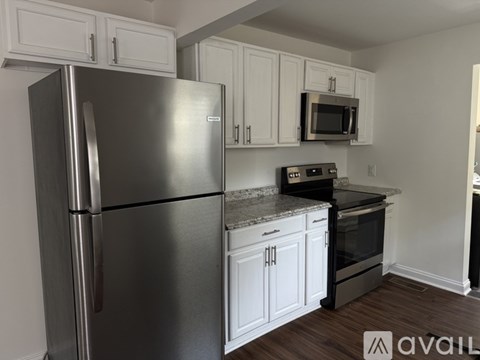 A kitchen with a stainless steel refrigerator and black appliances.