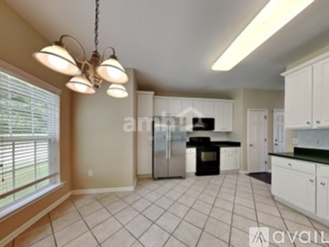 A kitchen with white cabinets and a black stove top oven.