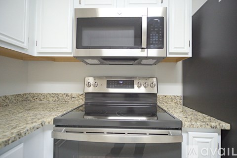 A modern kitchen with a stainless steel oven and microwave above it.