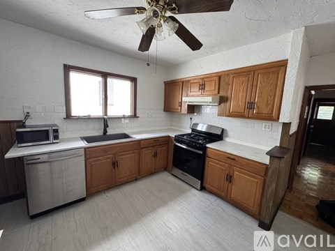 A kitchen with wooden cabinets and a stainless steel sink.