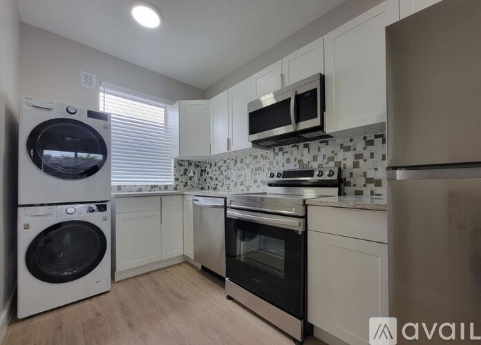 A kitchen with a washing machine and an oven.