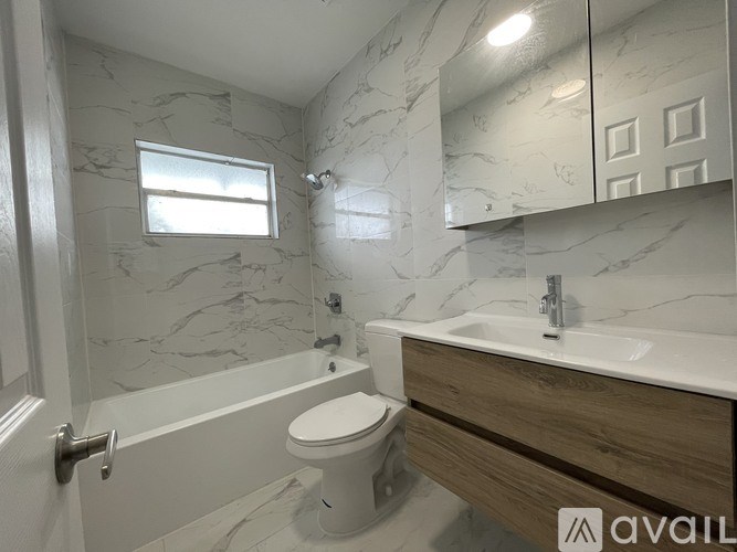 A bathroom with marble walls and a white toilet.