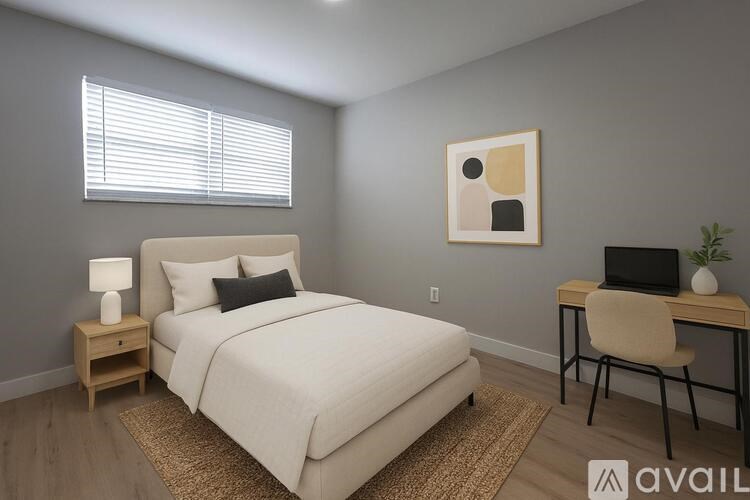 A bedroom with a bed, desk, and chair.