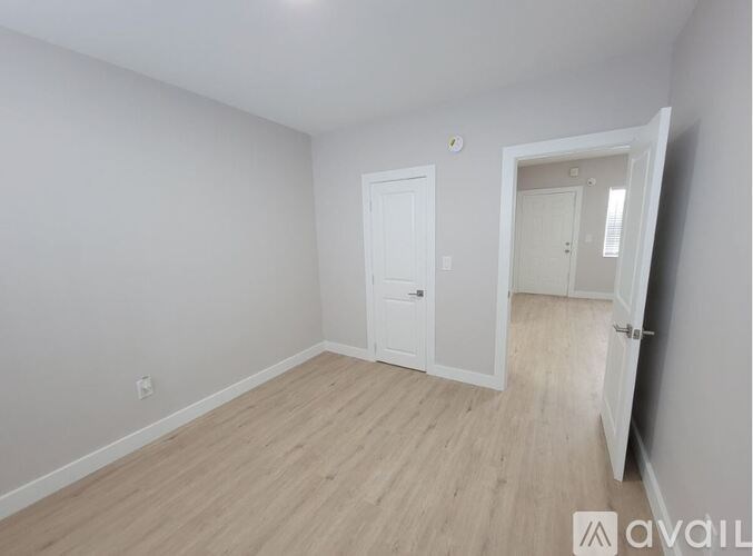 A room with a white door and a white wall.