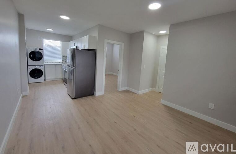 A kitchen area with a refrigerator, dishwasher, and a washing machine.