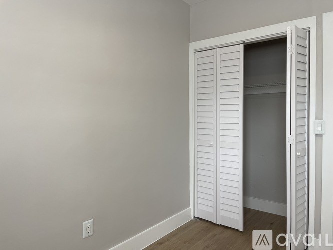 A white closet with a door open and shelves inside.