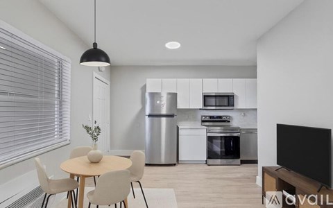 A modern kitchen with a dining table and chairs.
