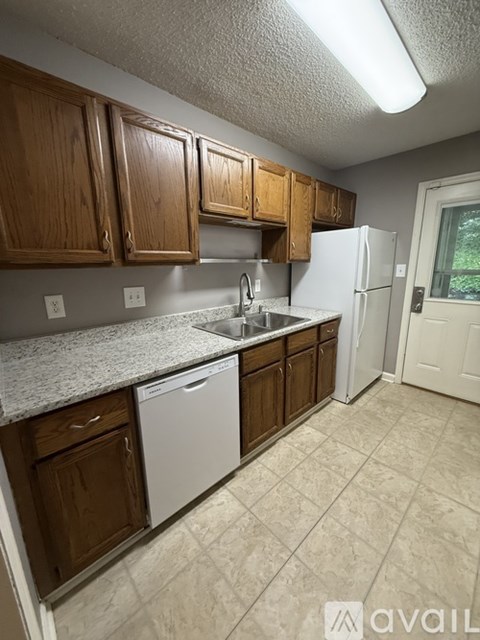 A kitchen with wooden cabinets and a white refrigerator.