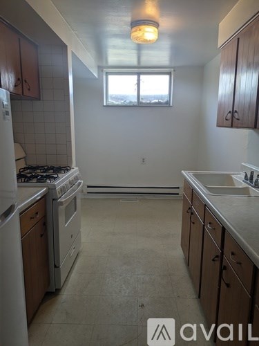 A kitchen with brown cabinets and a white dishwasher.