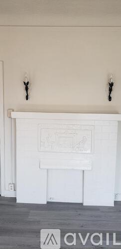 A white fireplace with a drawing above it.