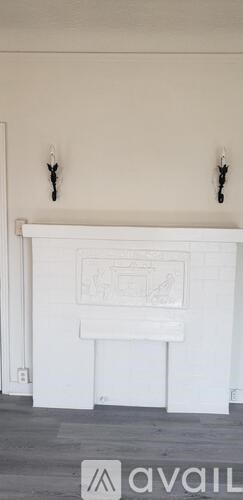 A white fireplace with a drawing above it.