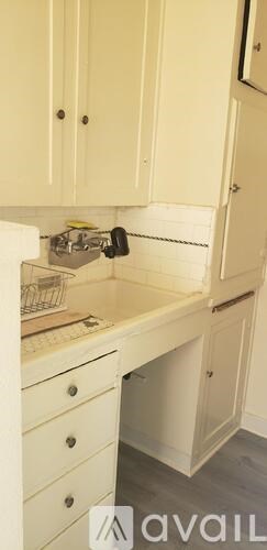 A kitchen with white cabinets and a white countertop.