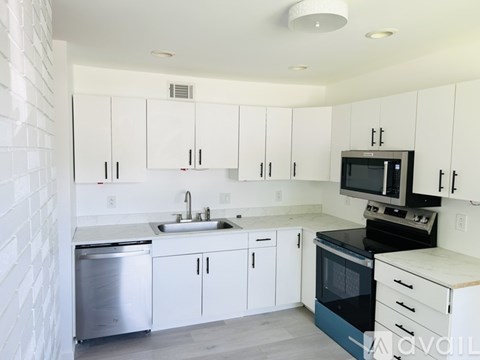A kitchen with white cabinets and a black stove top oven.