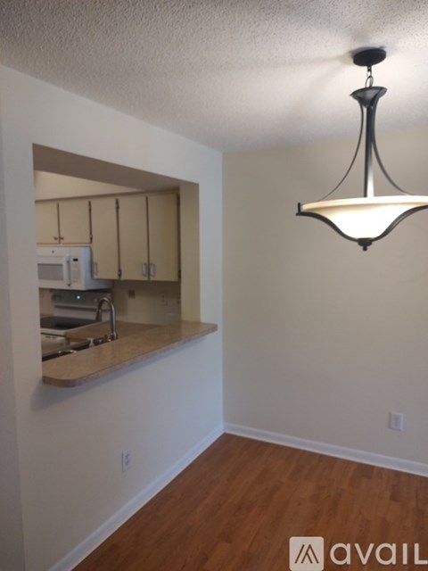 A kitchen area with a sink and a mirror.