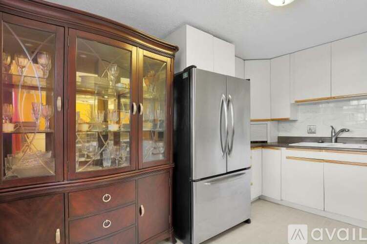 A kitchen with a refrigerator and wooden cabinets.