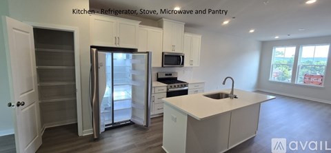 A kitchen with a refrigerator, stove, microwave and pantry.