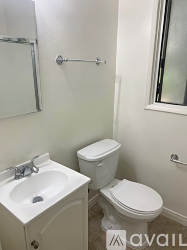 A white toilet and sink in a small bathroom.