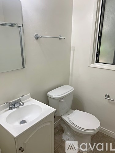 A white toilet and sink in a small bathroom.
