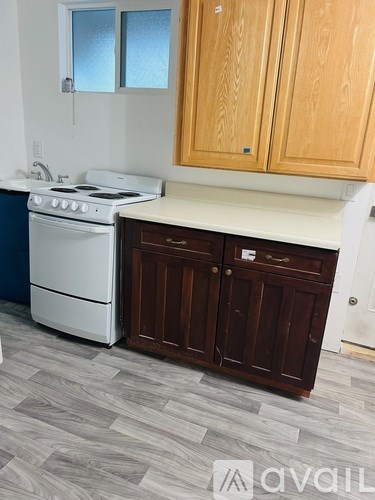 A kitchen with a white stove and wooden cabinets.
