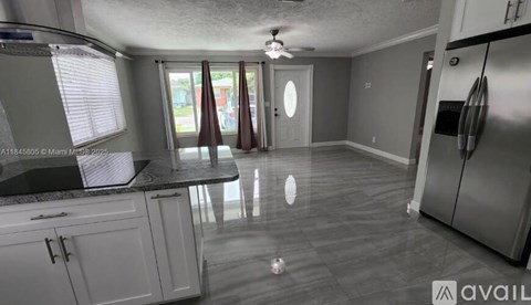 A kitchen with white cabinets and a marble countertop.