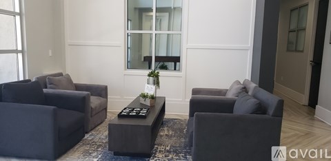 A living room with grey couches and a black coffee table.
