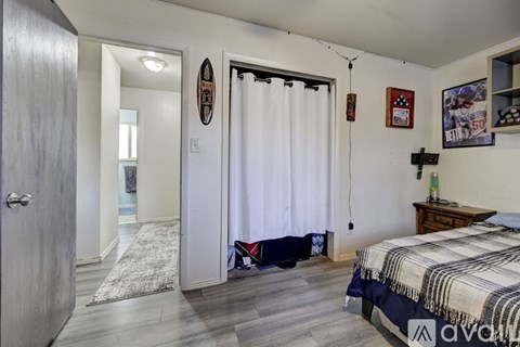 A bedroom with a bed, a dresser, and a mirror.