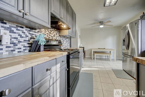 A kitchen with a tile backsplash and stainless steel appliances.