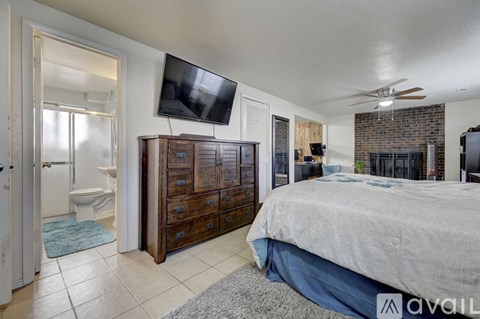 A bedroom with a bed, dresser, and television.