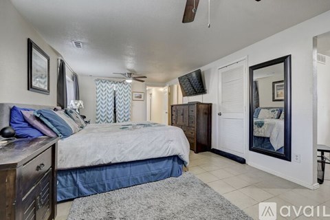 A bedroom with a bed, dresser, and mirror.