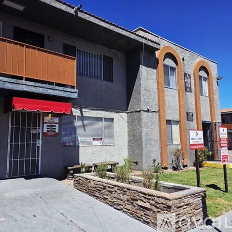 A building with a red awning and a stone wall in front.