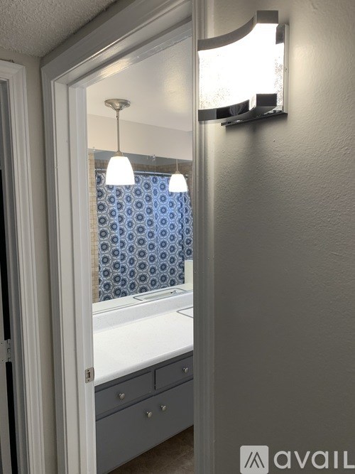 A bathroom with a white tub and blue tiles.