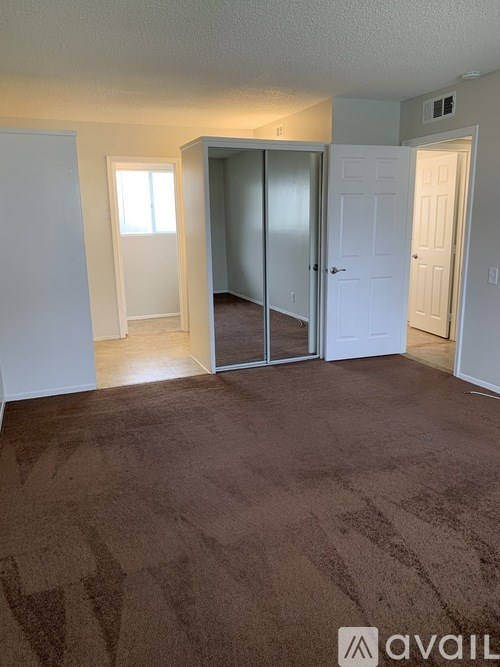 A room with brown carpet and a white door.