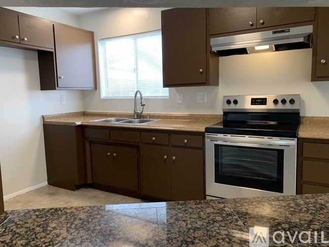 A kitchen with brown cabinets and a black stove top oven.