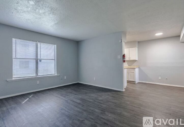 A room with a window and a wooden floor.