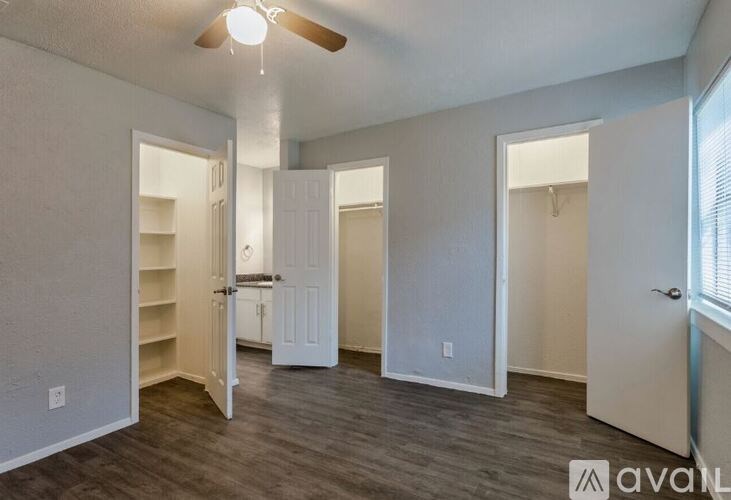 A room with a ceiling fan and a doorway leading to another room.
