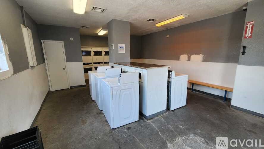 A room with a bench, a door, and a wall with a sign on it.