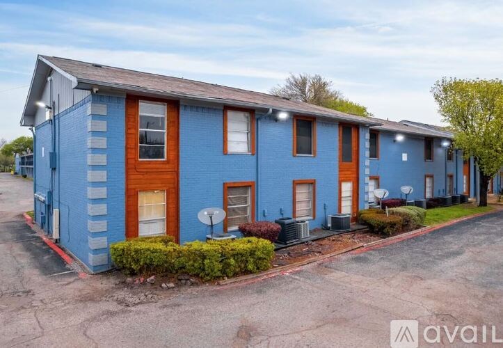 A row of blue houses with red doors and windows.
